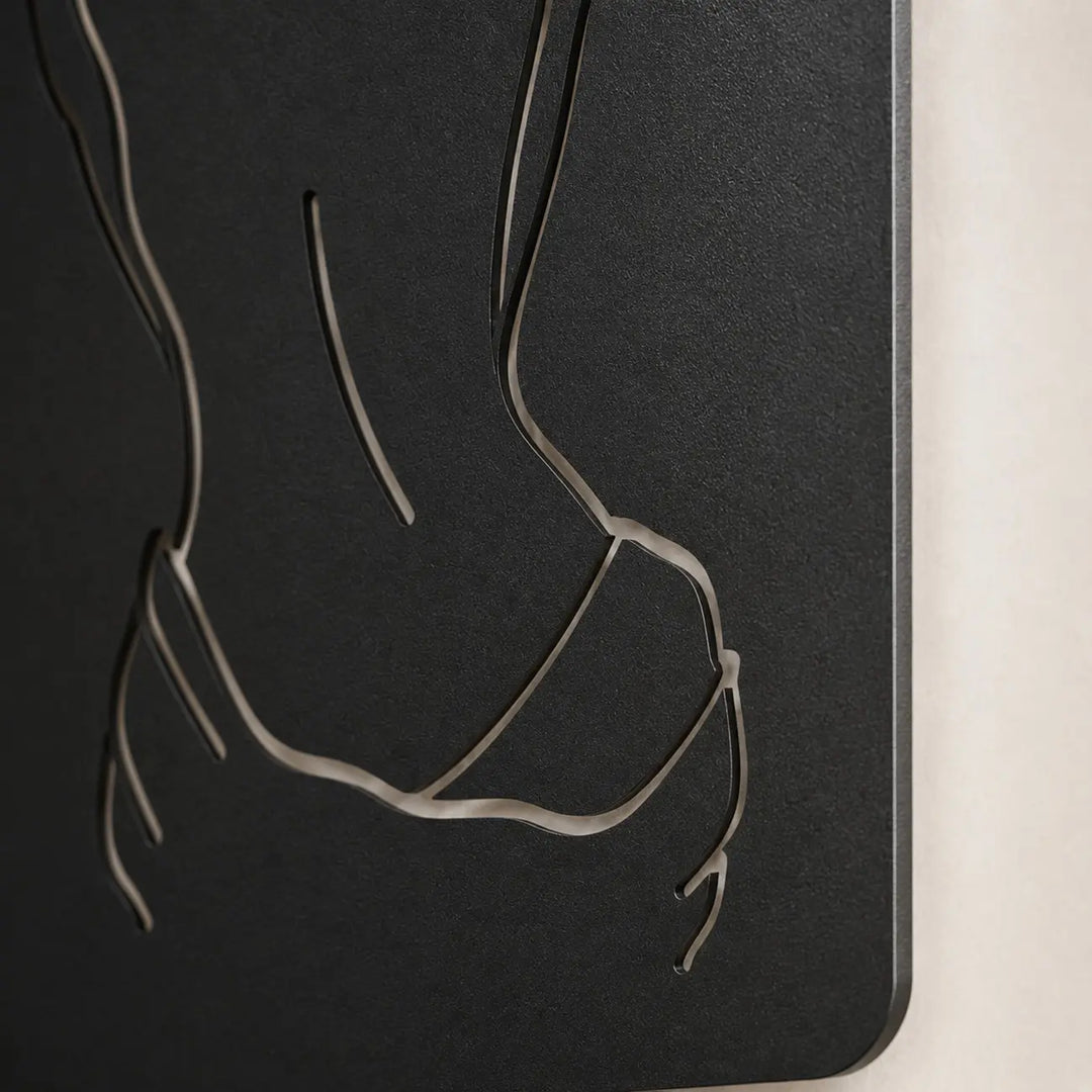 Detailopname van het elegante vrouwelijke silhouet in premium metaal. Het blinde ophangsysteem zorgt voor een prachtig zwevend 3D-schaduweffect op de muur.