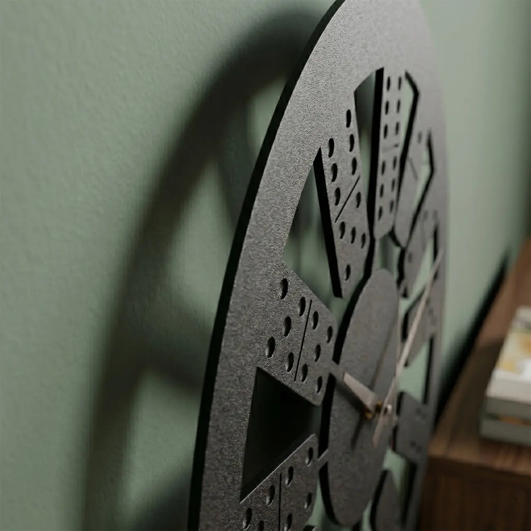 Detailopname van de matzwarte metalen domino klok. Het innovatieve design en de afstandhouders creëren een prachtig zwevend 3D-schaduweffect op de muur.