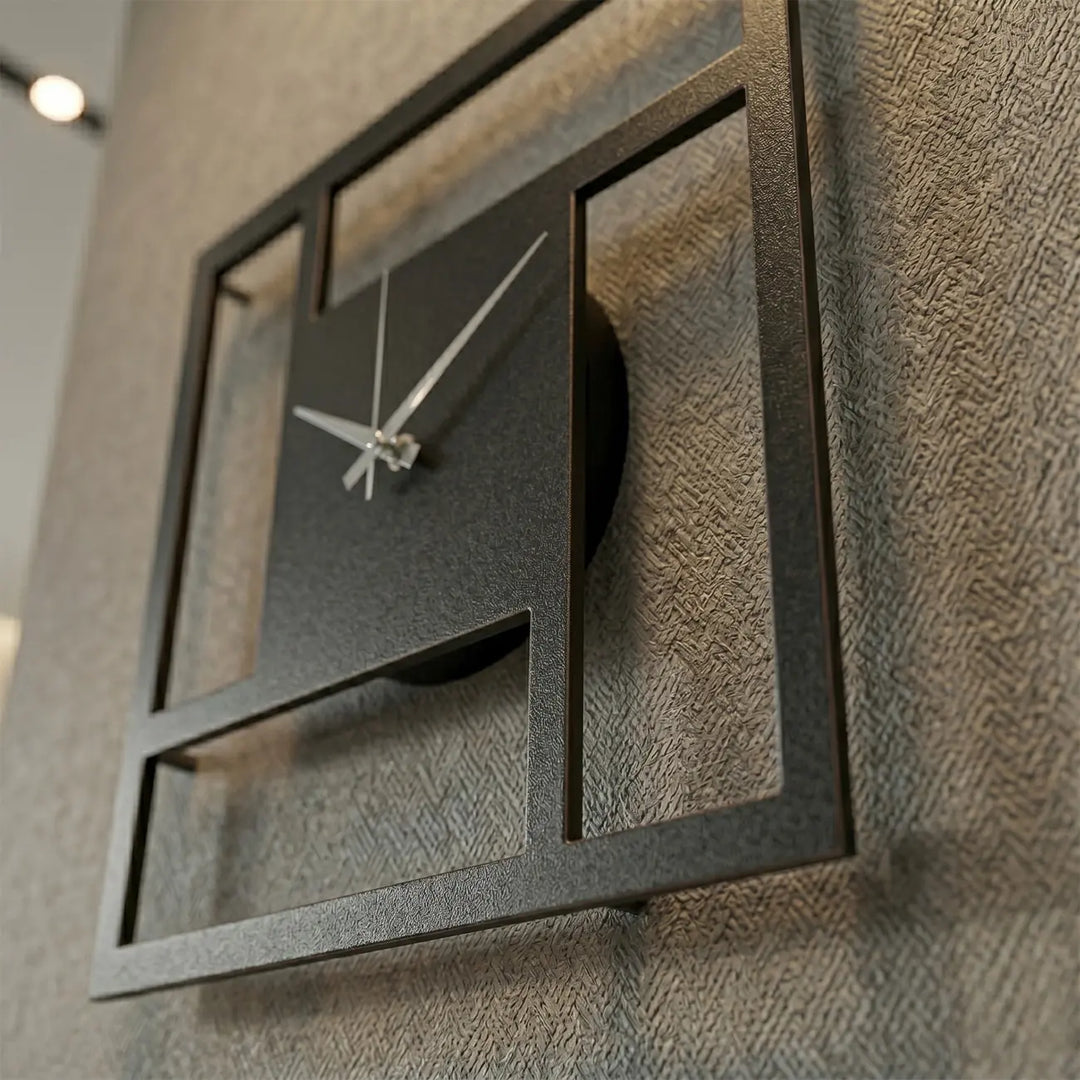 Detailopname van de vierkante metalen wandklok. Het minimalistische geometrische design en de wandafstandhouders zorgen voor een strak 3D-schaduweffect.