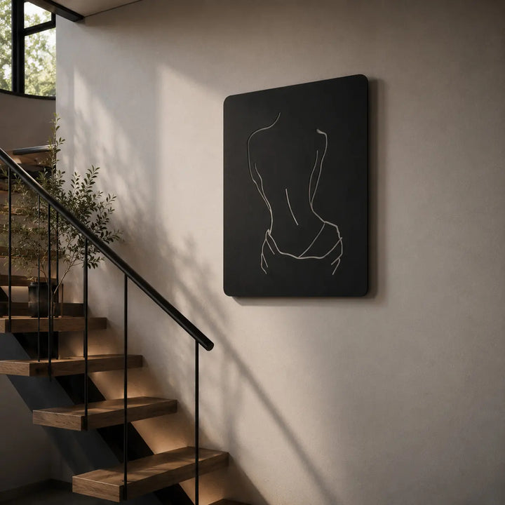 Elegante metalen wanddecoratie van een vrouwenrug. Een minimalistische en chique toevoeging om de grote lege muur in het trappenhuis stijlvol te verfraaien.