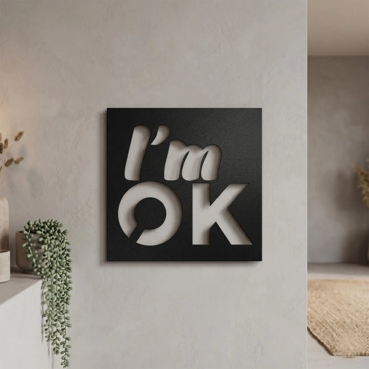 Zwarte metalen 'I'm OK' tekst in de hal naast de spiegel. Een positieve bevestiging en warme welkomstboodschap zodra u thuiskomt.