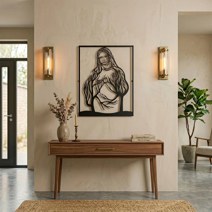 Elegante zwarte metalen Maria wanddecoratie boven de sidetable in de gang. Strakke christelijke kunst die direct warmte en betekenis geeft aan een lichte hal.