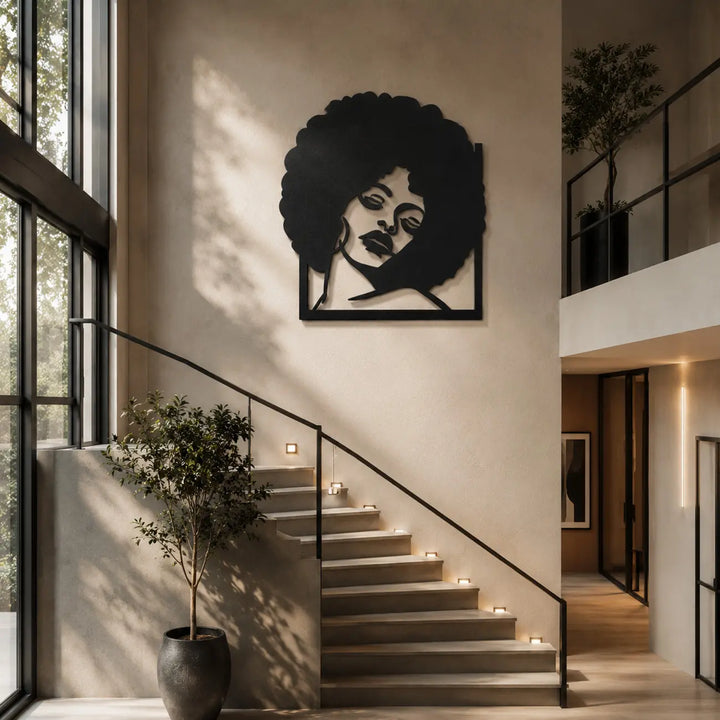 Indrukwekkende afro vrouw metalen wanddecoratie als prachtig statement piece boven de trap in een luxe huis. Impressive afro woman metal wall decor as a beautiful statement piece above the stairs in a luxury home.