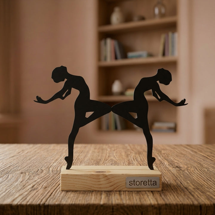 Metalen sculptuur van twee synchroon dansende ballerina's op geüpcycled massief hout behandeld met teakolie.