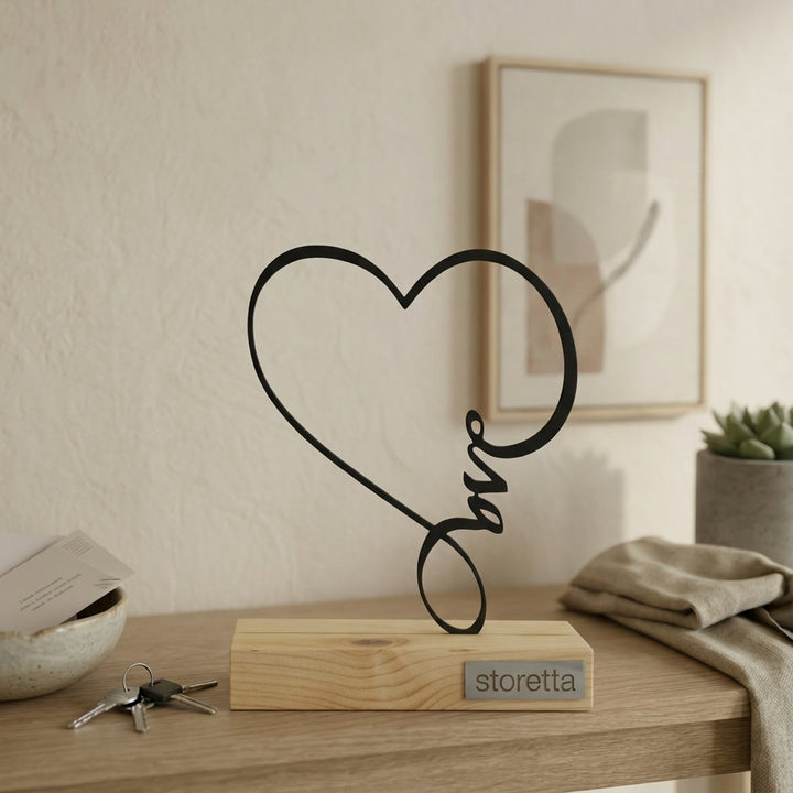 Minimalistisch decoratiebeeld van een vloeiend hart, passend bij interieurs met mangohout en zwart staal.