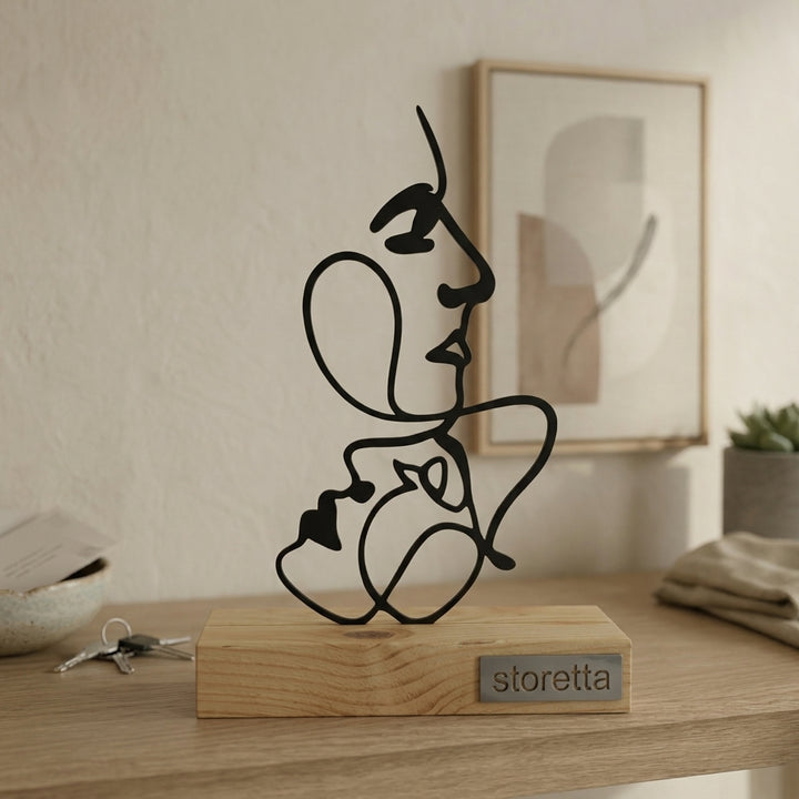 Minimalistisch decoratiebeeld van verweven gezichtscontouren, passend bij interieurs met mangohout en staal.