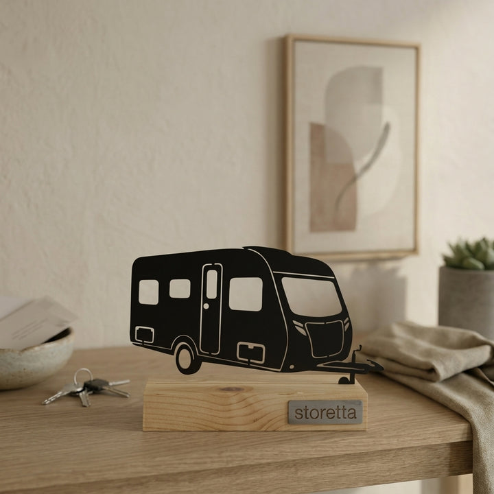 Minimalistisch decoratiebeeld van een toercaravan, passend bij interieurs met mangohout en staal.