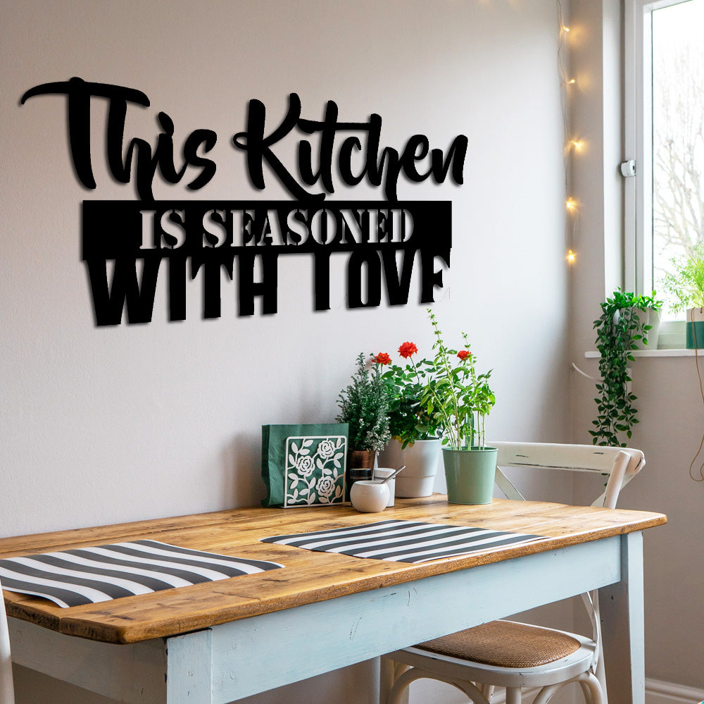 Strakke zwarte metalen wandtekst over liefde en koken. Vormt een prachtig, warm contrast in een moderne en minimalistische keuken.