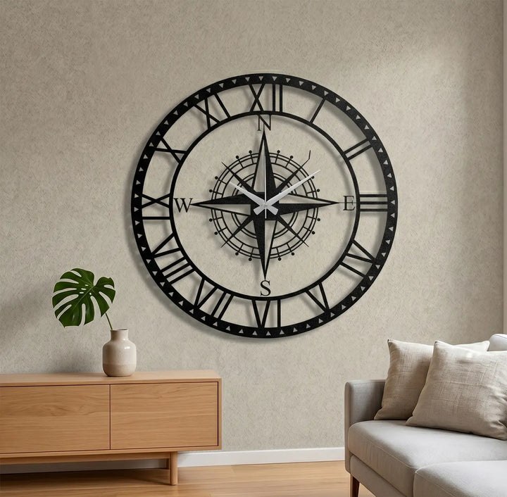 Zwarte metalen Cardinal Compass klok aan de muur in een gezellige zithoek. Een tijdloos designstuk voor een warme sfeer in huis.