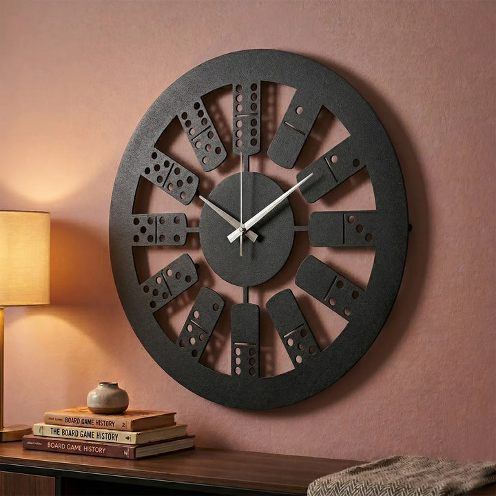 Opvallende metalen domino klok in een gezellige zithoek of spelletjeshoek. Combineert functionaliteit met een creatief wanddesign.