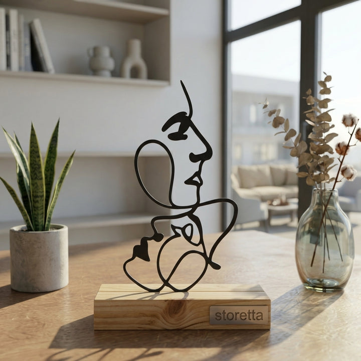 Eigentijdse tafeldecoratie van metaal en hout met een abstract Picasso-stijl gezichten silhouet in daglicht.