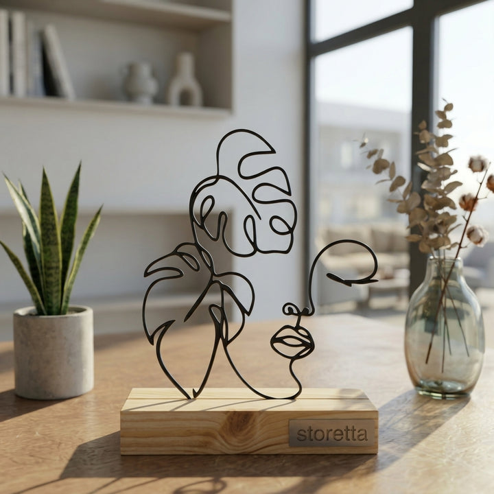 Eigentijdse tafeldecoratie van metaal en hout met botanisch line art profiel in natuurlijk daglicht