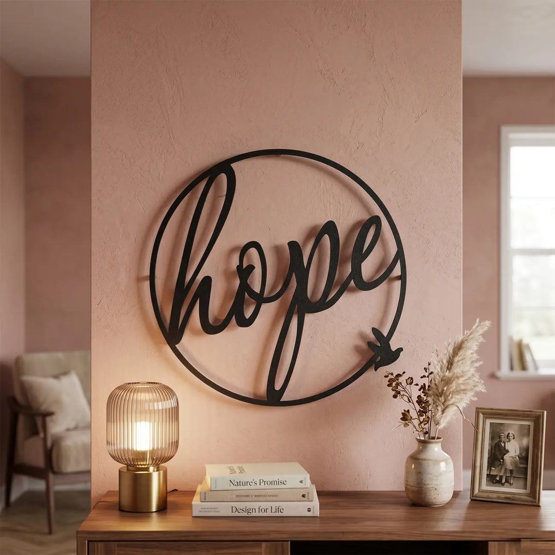 Zwarte metalen wanddecoratie 'Circle of Hope' met een vogel. Een inspirerend en warm welkom boven de sidetable in een moderne hal of entree.